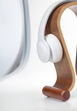 Tahta bir omega standında HIFI kulaklıklar (High Fidelity). Beyaz arkaplanda izole.