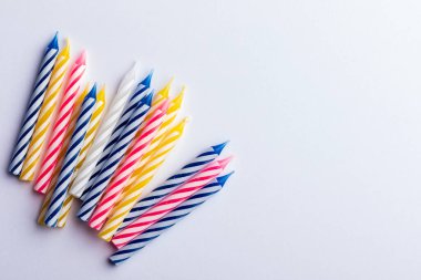 Beyaz arka planda bir grup doğum günü mumları. Doğum günü tebrik kartı için. Metin eklemek için boşluk. Çok renkli, mavi, kırmızı, sarı ve beyaz.