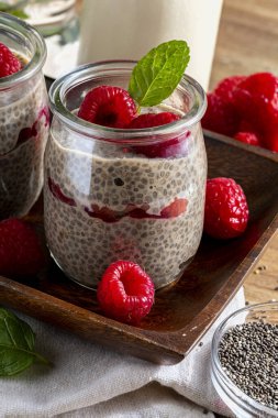 İştah açıcı, sağlıklı ve taze ahududu, nane yaprağı ve kurabiyeli taze chia tohumu pudingi. Sağlıklı vejetaryen ve vejetaryen yemekleri. Ev yapımı görünüş.