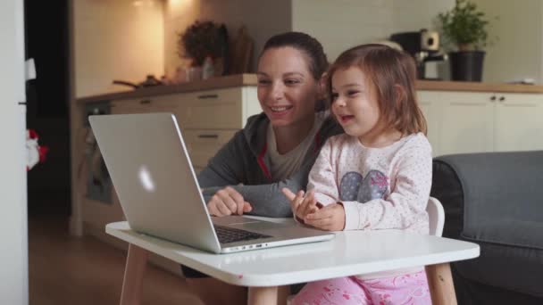 Madre e figlia ragazza seduta a casa annuncio guardando il video della scuola sul computer portatile. Educazione a distanza, scolarizzazione a casa. — Video Stock