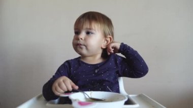 Genç kız silikon önlükle tek başına çorba içiyor.