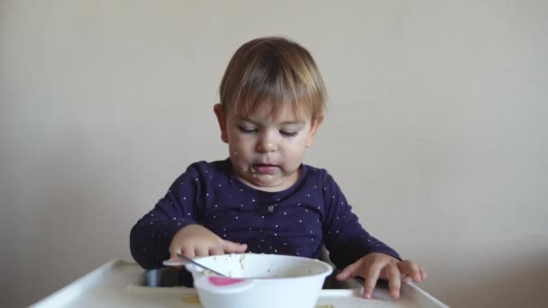 Joven niña witth babero de silicona comer sopa sola con cuchara — Vídeos de Stock