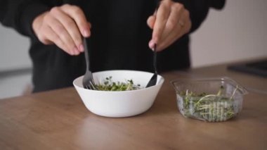 Genç bayan turp mikroyeşilliklerinden salata hazırlıyor. Sağlıklı yaşam tarzı, süper yiyecekler