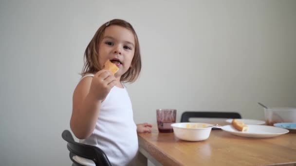 Kaukasisches Kleinkind isst Toast zum Frühstück zu Hause — Stockvideo