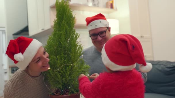 Família caucasiana feliz decorar árvore de Natal sozinho em casa. quarentena de ano novo — Vídeo de Stock