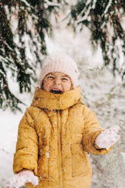 Küçük kız kışın kar tatilinden memnun. Noel tatilinde dışarıda oynamak.