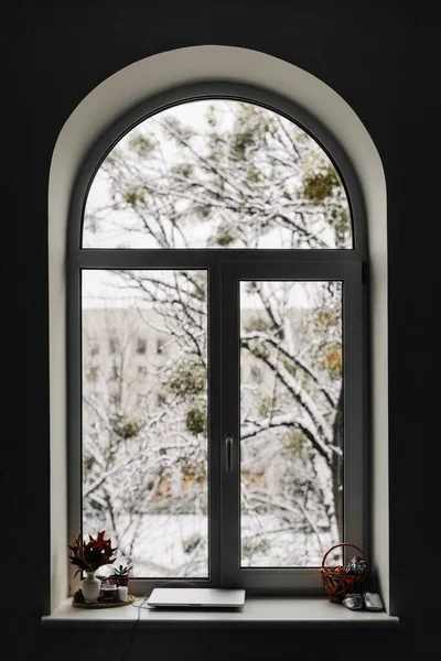 Θέα μέσα από το παράθυρο αψίδα στο χιονισμένο σκηνή. Χριστούγεννα στο σπίτι — Φωτογραφία Αρχείου