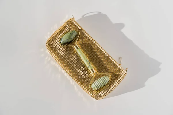 Ρολό χαλαζία προσώπου για αντιγηραντικό μασάζ προσώπου, κινέζικο εργαλείο ομορφιάς guasha, χρυσή τσάντα — Φωτογραφία Αρχείου