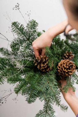 Çam çelengi asan bir çiçekçi kız. Çiçekçi kadın dekorasyonu. Noel Arası Dekorasyonu