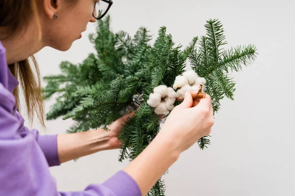 Una florista con una guirnalda de pino colgante. Mujer florista decorando. Decoración de Navidad DIY —  Fotos de Stock
