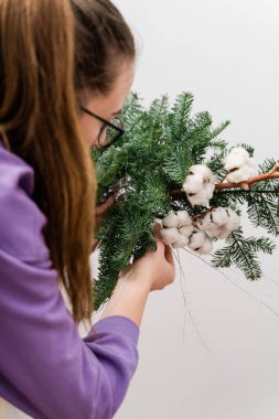 Çam çelengi asan bir çiçekçi kız. Çiçekçi kadın dekorasyonu. Noel Arası Dekorasyonu