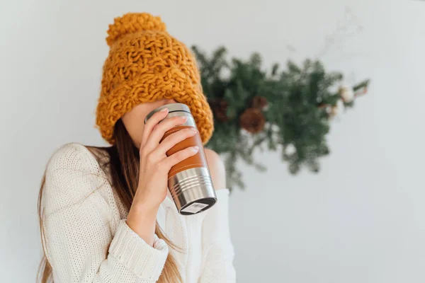 Mulher em chapéu laranja e metal reutilizável caneca termo no dia de Natal de inverno. Vida sustentável — Fotografia de Stock