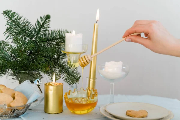 Christmas table with golden candles, honey and pine — Stock Photo, Image