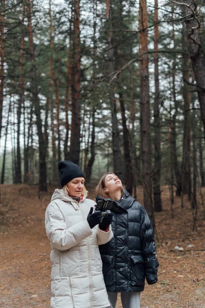 Mujer caucásica con hija adulta volando avión no tripulado en el bosque de otoño. — Foto de Stock