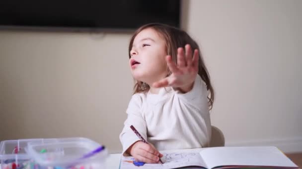 Küçük kız tek başına boyama kitabı yapıyor. Kes jesti, çocuk özel hayatı. Ebeveynlerin sosyal medya sorunu. Okul öncesi etkinlik, evde eğitim. Yaratıcı sanatçı — Stok video