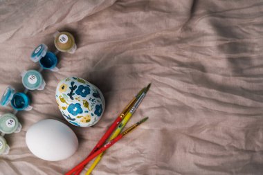 Çiçek desenli boyanmış tavuk yumurtası. Paskalya tatili için çocuklarla el işi. Botanik dekorasyonu. Keten doğal bez arka plan. Bahar tatili için el işi