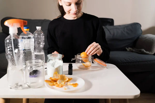 Millennial girl doing diy cleaning spray at home with vinegar, soda and lemon. Zero waste sustainable lifestyle. Environmentally friendly home. Spring cleaning