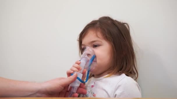 Dziewczynka z nebulizatorem tlenowym w domu. Leczenie wziewne zapalenia oskrzeli i choroby płuc. Leczenie astmy i alergii. — Wideo stockowe