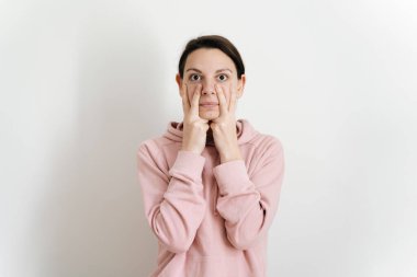 Evinde yüz yogası yapan genç ve güzel bir kadın. Genç, heykel gibi bir yüz yapmak için harika egzersizler. Yaşlanmayı önleyen kişisel bakım rutini. Yüz kasları konsepti oluşturma