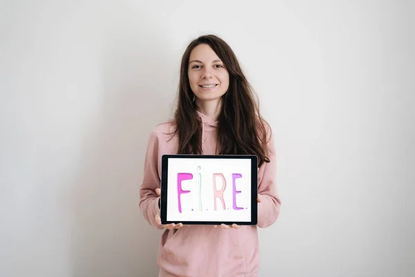 Genç milenyum kadını ateş hareketinden memnun. Mali Bağımsızlık, Erken Emekli Konsepti. Ekstrem tasarruflar ve yatırımlarla yaşamak. Çalışmadan sağlıklı ve düşünceli bir yaşam tarzı.. 