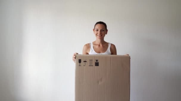 Joven reubicación mujer miillennial con caja de cartón enorme. Compra en línea, persona de entrega. — Vídeos de Stock