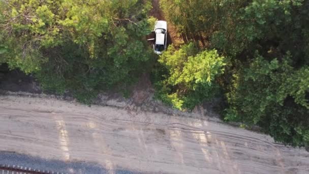 Letecký pohled na zelenou lesní krajinu. Přírodní pozadí bílého auta v lese. Drone View. Pohled z ptačího oka. Koncept výletu, udržitelné místní cestování. Skvělé venku — Stock video