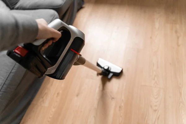 Limpeza de piso de madeira com aspirador sem fio. Limpador sem fio portátil. Aparelho doméstico. Trabalho doméstico equipamento moderno — Fotografia de Stock