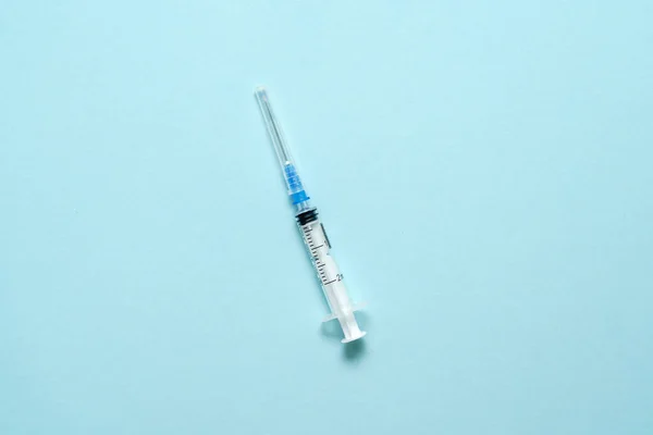 Ovanifrån på injektionssprutan på blå bakgrund. Minimalt vaccinkoncept. Medicinsk behandling av diabetes med insulin. Vaccination med Covid-19. Kampanj mot Antivax — Stockfoto