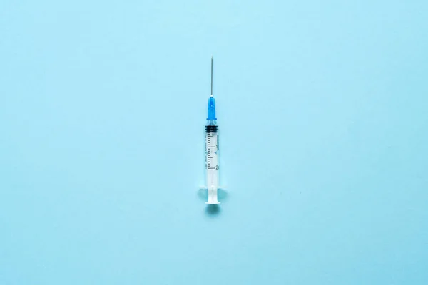 Ovanifrån på injektionssprutan på blå bakgrund. Minimalt vaccinkoncept. Medicinsk behandling av diabetes med insulin. Vaccination med Covid-19. Kampanj mot Antivax — Stockfoto