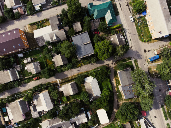 Aerial view of suburb of European city. Green neighbourhood on a sunny summer day. County living. Drone point of view. High quality photo