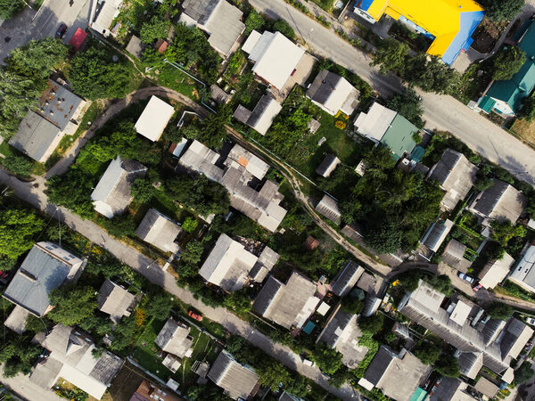 Aerial view of suburb of European city. Green neighbourhood on a sunny summer day. County living. Drone point of view. High quality photo