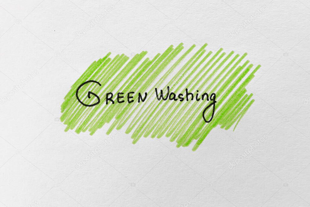 Greenwashing concept. Drawing on paper with text and green marker strokes. Environmental marketing disinformation. Non transparent green sheen.