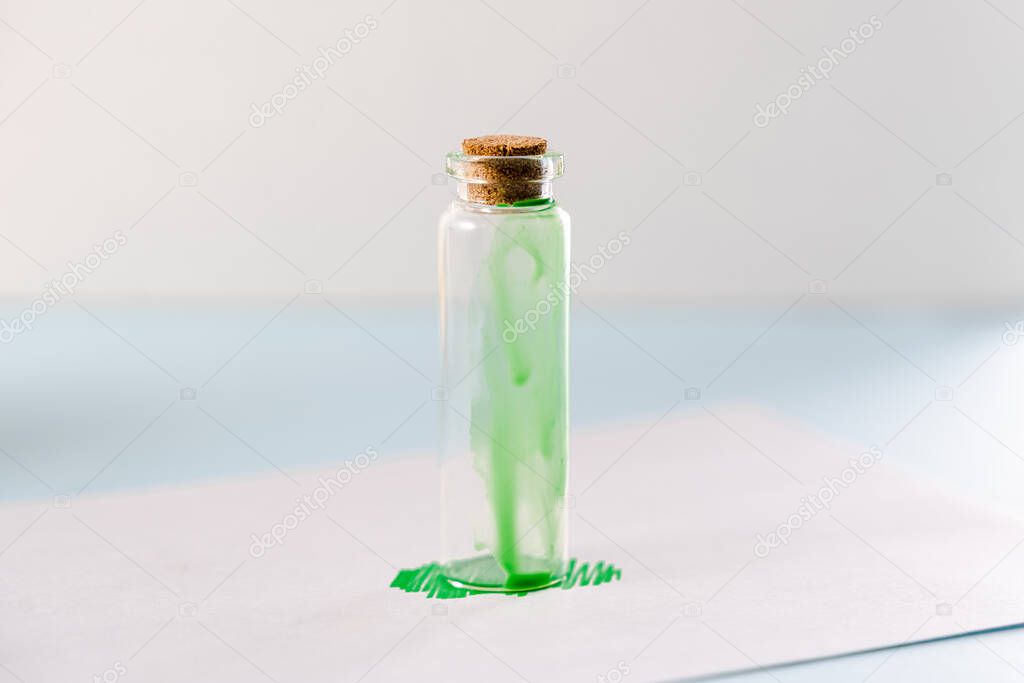 Greenwashing concept. Green paint and cosmetics bottle. Environmental marketing disinformation. Non transparent green sheen.