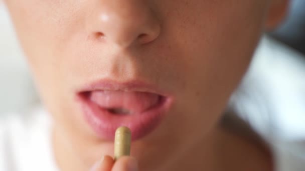 Primer plano de la boca de la mujer con cápsula vitamínica. Micro dosificación para el tratamiento de la depresión. Vitaminas y suplementos medicina preventiva — Vídeos de Stock