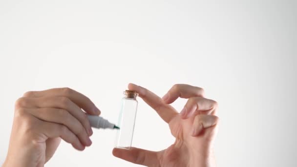 Concepto de lavado verde - manos pintando botella en verde. Marcador verde y botella de cosméticos. Desinformación de marketing ambiental. Brillo verde no transparente. — Vídeo de stock