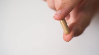 Beyaz arka planda bitki kapsülüyle elinizi kapatın. Mikrodoz konsepti. Psikedelik terapisi. Depresyon, endişe tedavisi 