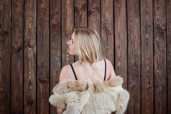 Blonde in the studio, wooden wall — Stock Photo, Image