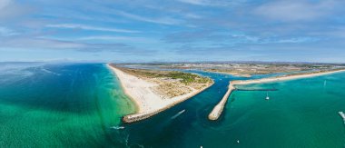 Portekiz 'in güneyindeki Algarve bölgesindeki Ria Formosa doğal parkının bir parçası olan Tavira kasabası yakınlarındaki tropikal bir ada olan Tavira Adası' nın havadan panoramik manzarası.