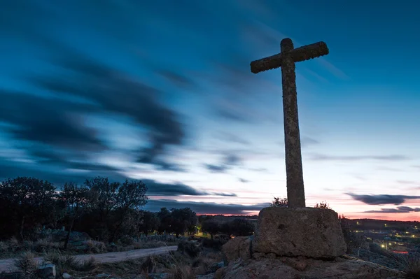 Croce di pietra con sfondo cielo crepuscolo nuvoloso — Foto Stock