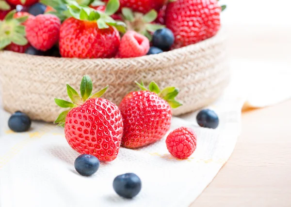 Bodegón de fresas en un tazón sobre un mantel de madera —  Fotos de Stock