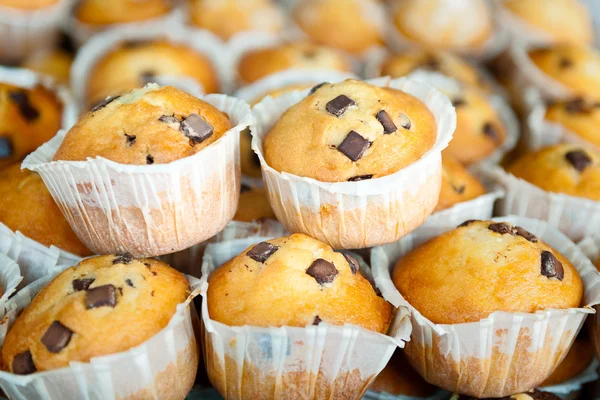 Muffins stacked together butter and chocolate in the foreground — Stock Photo, Image