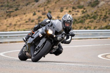 Ön planda yol bisikleti, asfaltta sürüyor ve virajda yatıyor. Fotoğraf Eylül 202 'de İspanya' nın Avila ilinde çekildi.