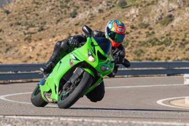 Ön planda yol bisikleti, asfaltta sürüyor ve virajda yatıyor. Fotoğraf Eylül 202 'de İspanya' nın Avila ilinde çekildi.