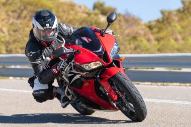 Ön planda yol bisikleti, asfaltta sürüyor ve virajda yatıyor. Fotoğraf Eylül 202 'de İspanya' nın Avila ilinde çekildi.