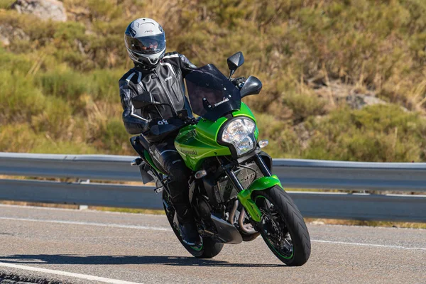 Ön planda yol bisikleti, asfaltta sürüyor ve virajda yatıyor. Fotoğraf Eylül 202 'de İspanya' nın Avila ilinde çekildi.