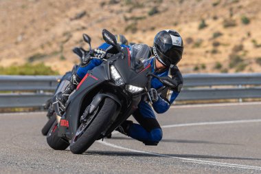 Asfalt üzerinde dolaşan motosikletçi; Eylül 2020 'de İspanya' nın Avila ilinde yakalanan fotoğraf