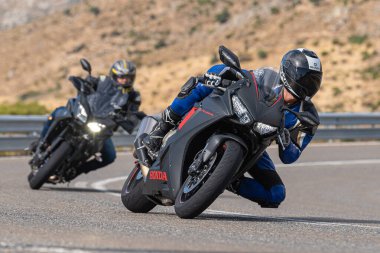 Asfalt üzerinde dolaşan motosikletçi; Eylül 2020 'de İspanya' nın Avila ilinde yakalanan fotoğraf