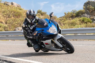 Asfalt üzerinde dolaşan motosikletçi; Eylül 2020 'de İspanya' nın Avila ilinde yakalanan fotoğraf