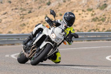 Asfalt üzerinde dolaşan motosikletçi; Eylül 2020 'de İspanya' nın Avila ilinde yakalanan fotoğraf