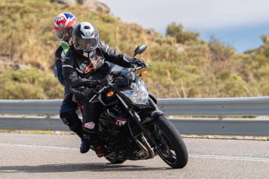 Asfalt üzerinde dolaşan motosikletçi; Eylül 2020 'de İspanya' nın Avila ilinde yakalanan fotoğraf